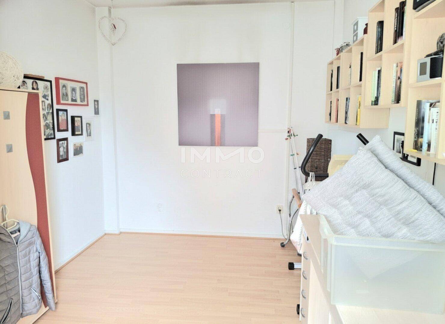 Helles Zimmer mit Holzfußboden, genutzt als Büro oder Abstellraum.