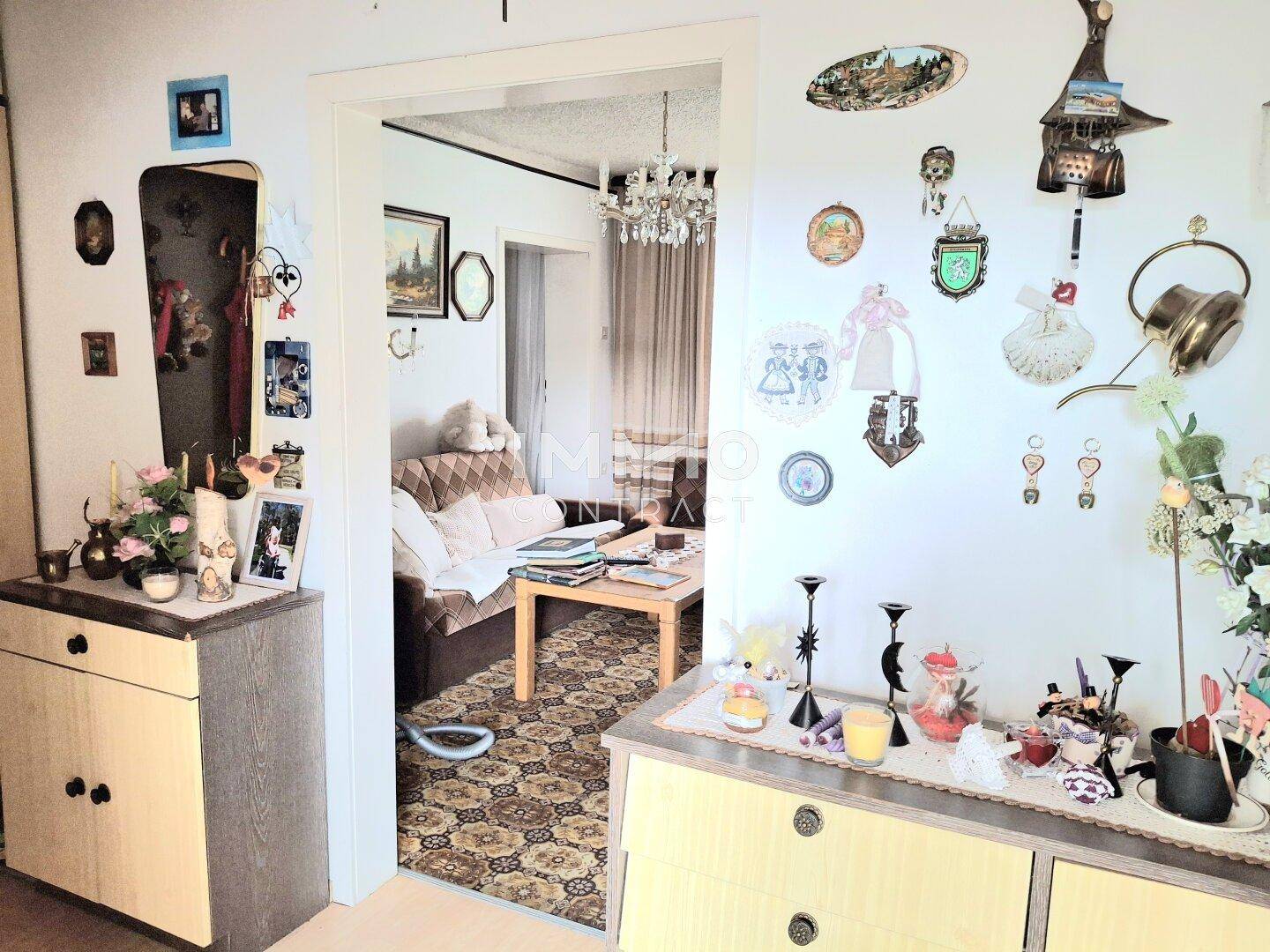 Gemütlicher Flur mit traditioneller Dekoration und Blick in ein angrenzendes Wohnzimmer.