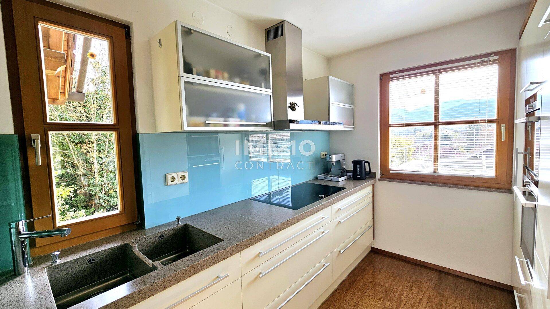 Funktionale Küche mit modernen Einbauschränken, Induktionskochfeld und Bergblick.