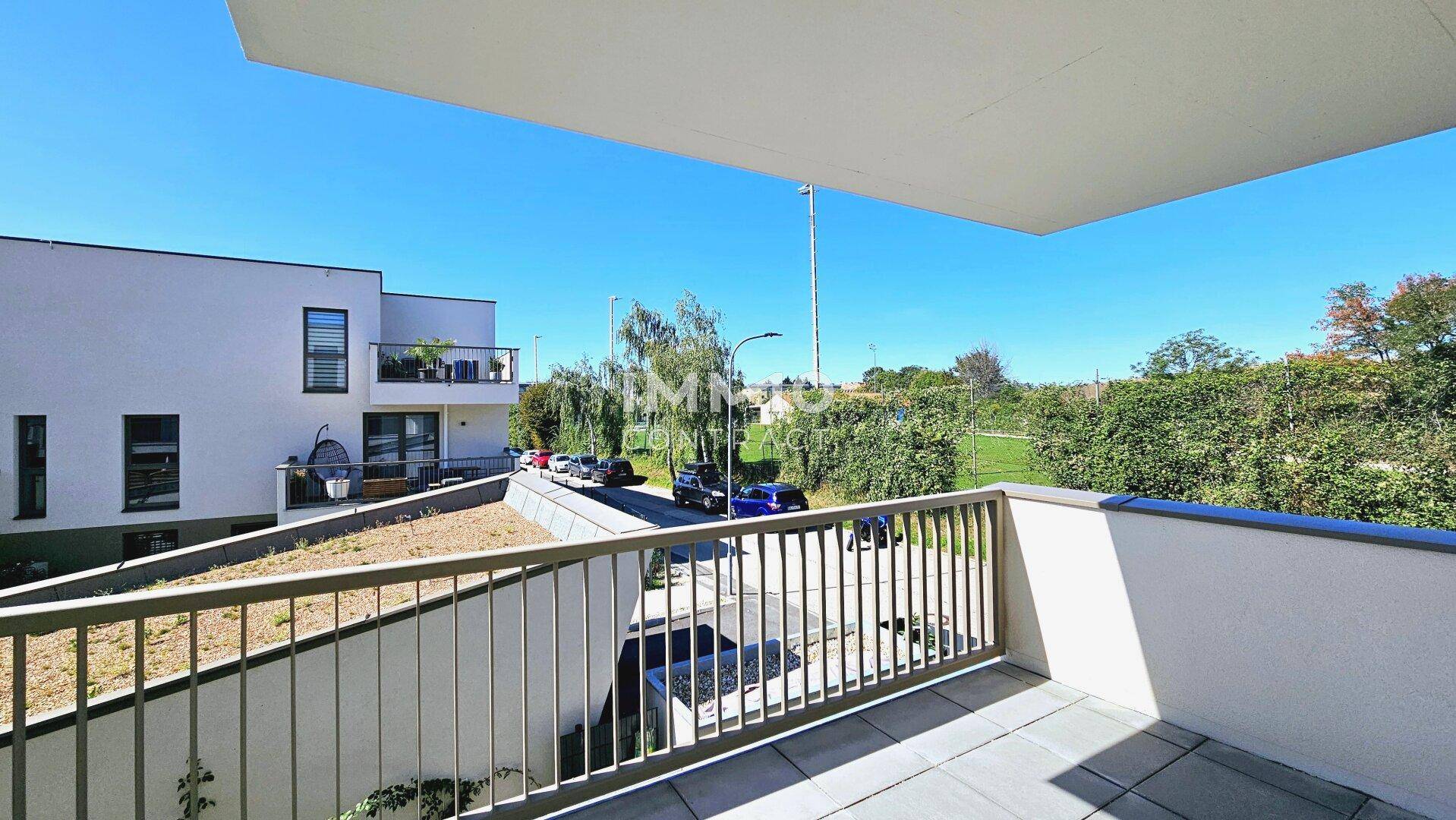 Geräumiger Balkon mit Blick auf die Straße und die umliegenden Gebäude und Grünflächen.