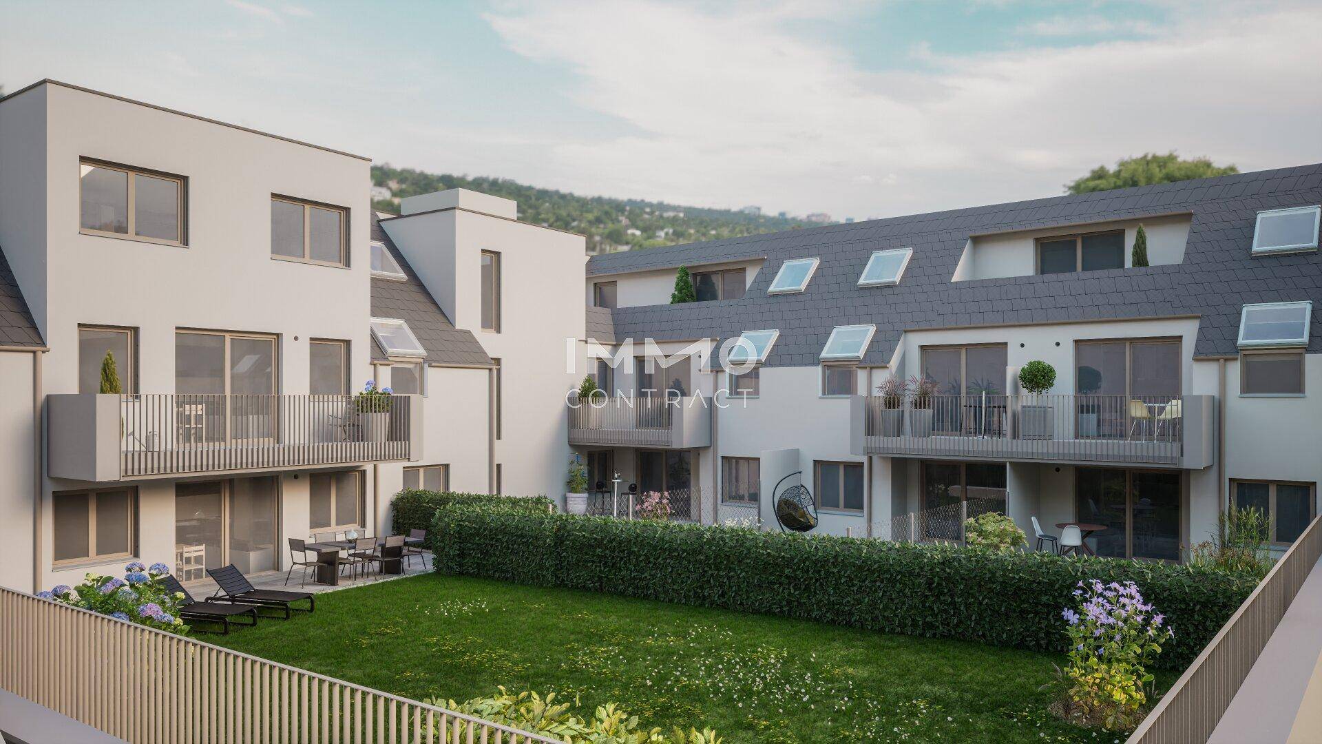 Rückansicht des Gebäudes mit privaten Terrassen, Balkonen und einer gepflegten Rasenfläche.