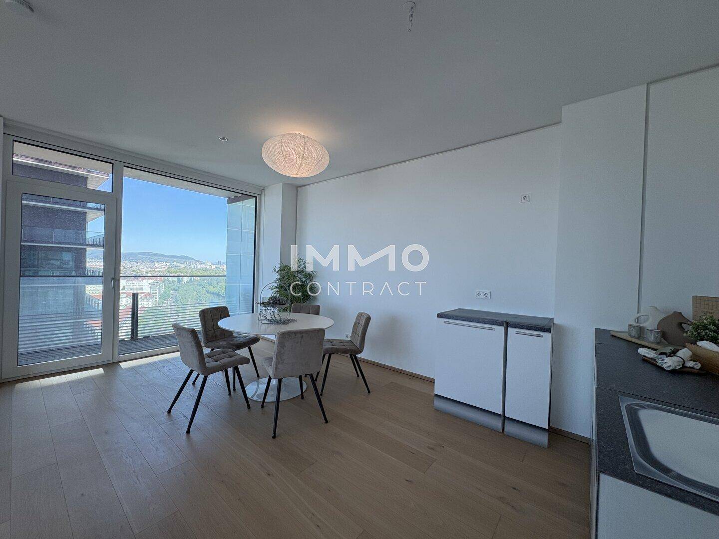 Heller Essbereich mit modernem Esstisch, Parkettboden und Zugang zum Balkon.