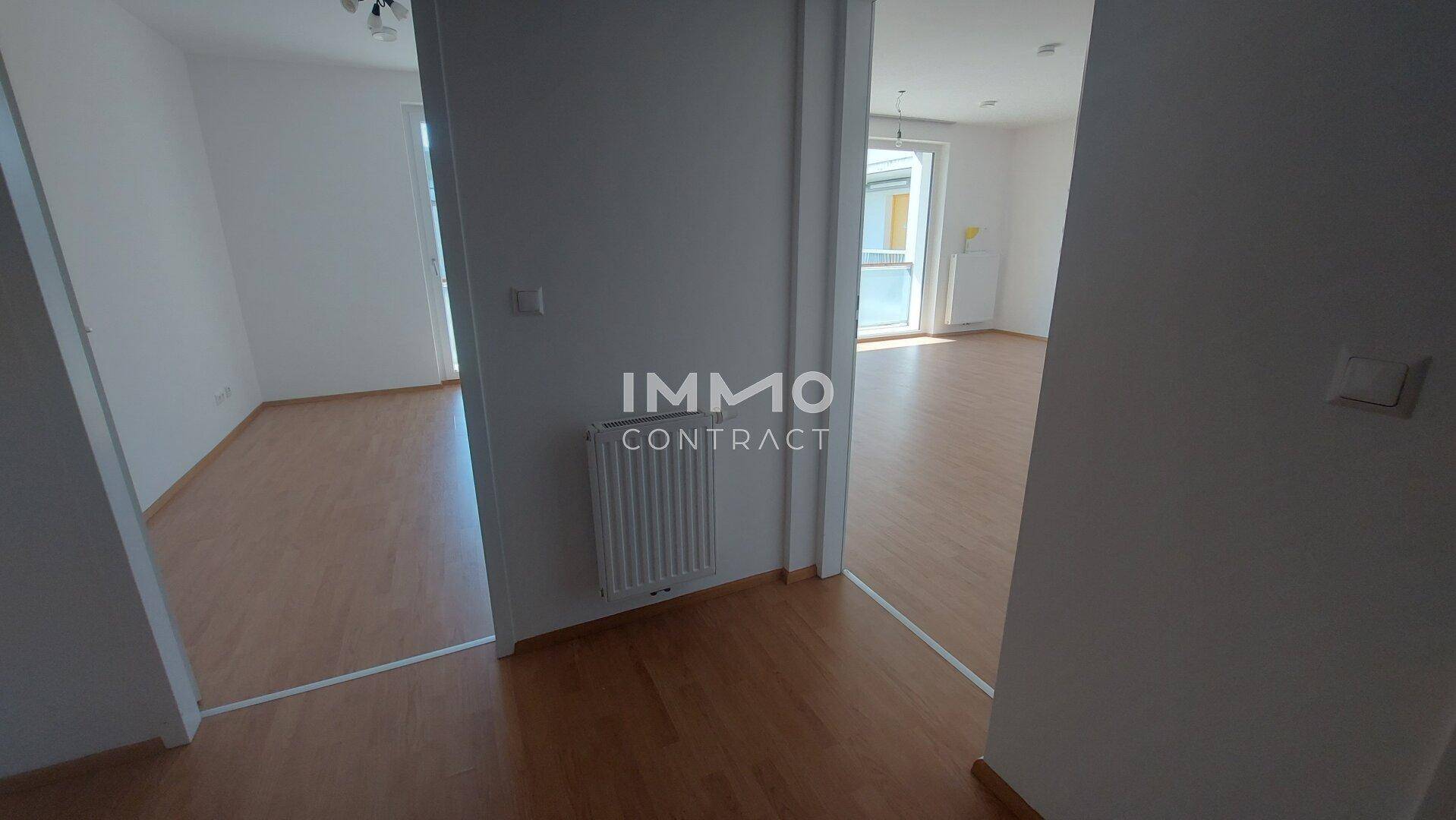 Heller Flur mit Laminatboden, der verschiedene Räume der Wohnung miteinander verbindet.