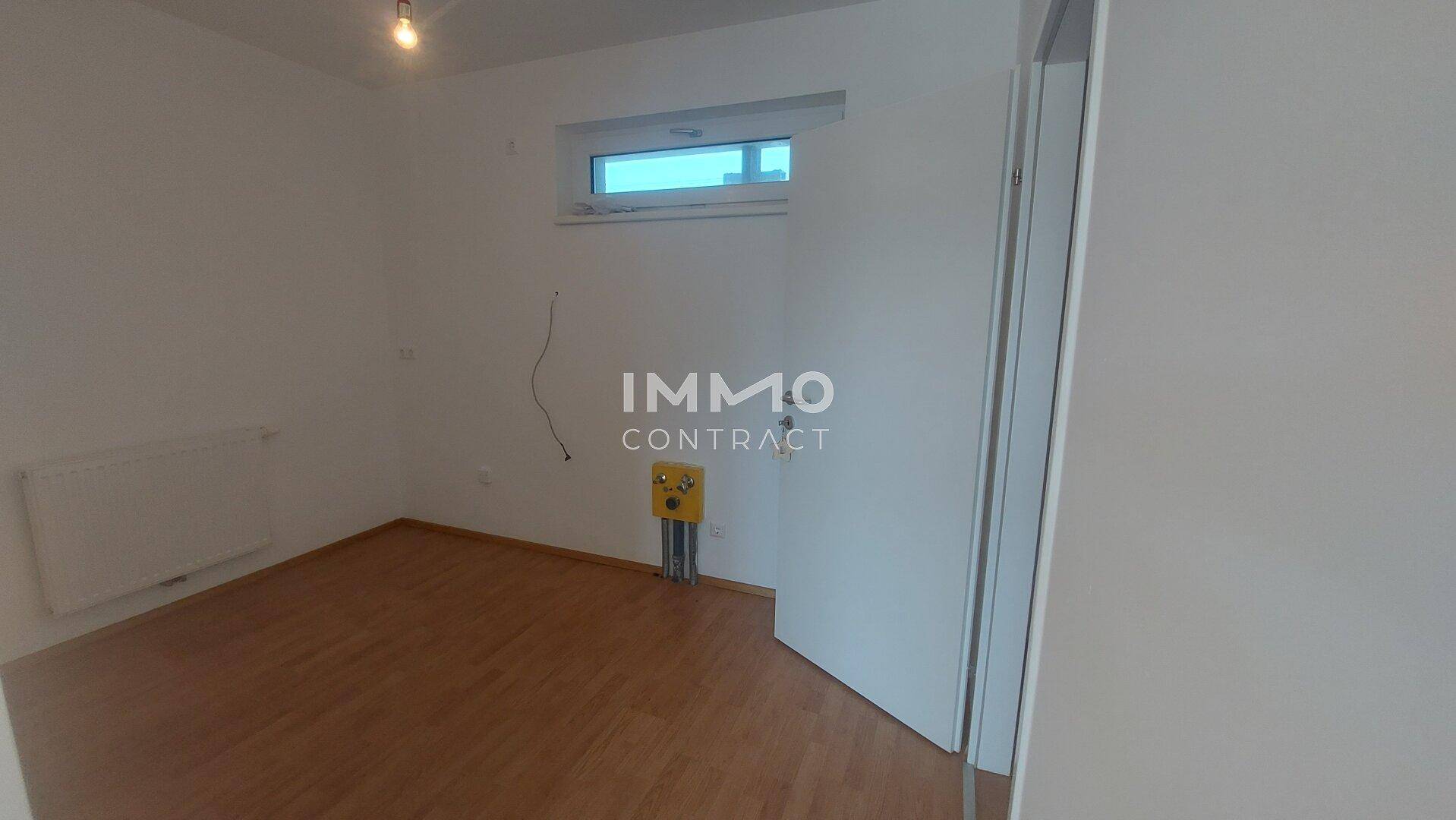 Vorbereiteter Küchenbereich mit Anschlüssen und Fenster, bereit für die Installation einer Einbauküche.