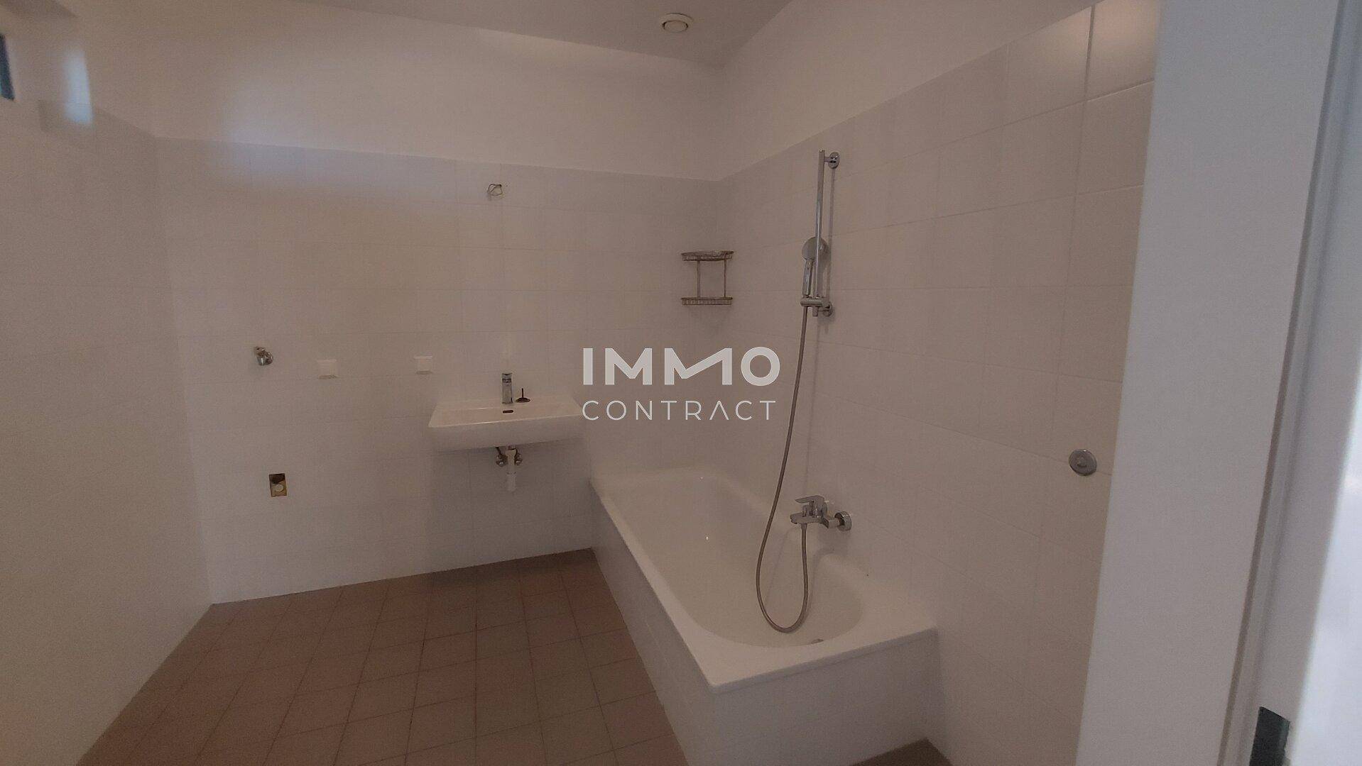Modernes Badezimmer mit Badewanne, Waschbecken und hellen Fliesen, bereit zur Nutzung.