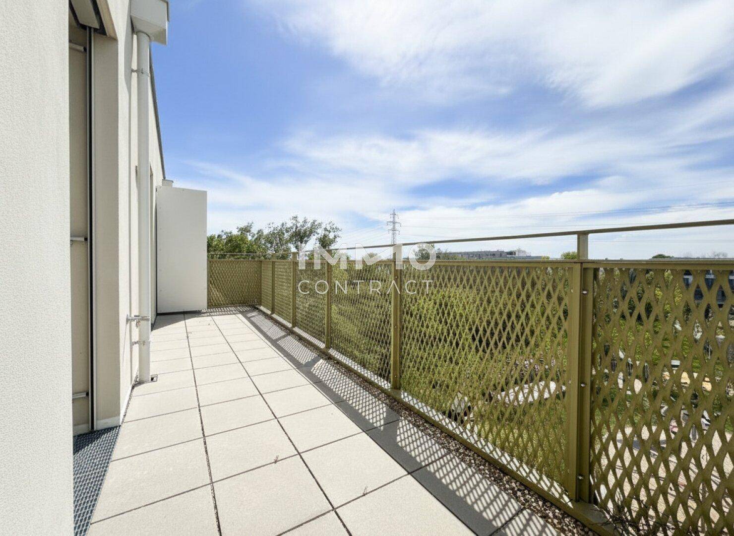 Sonniger Balkon mit Fliesenboden und Blick ins Grüne sowie auf die Umgebung.