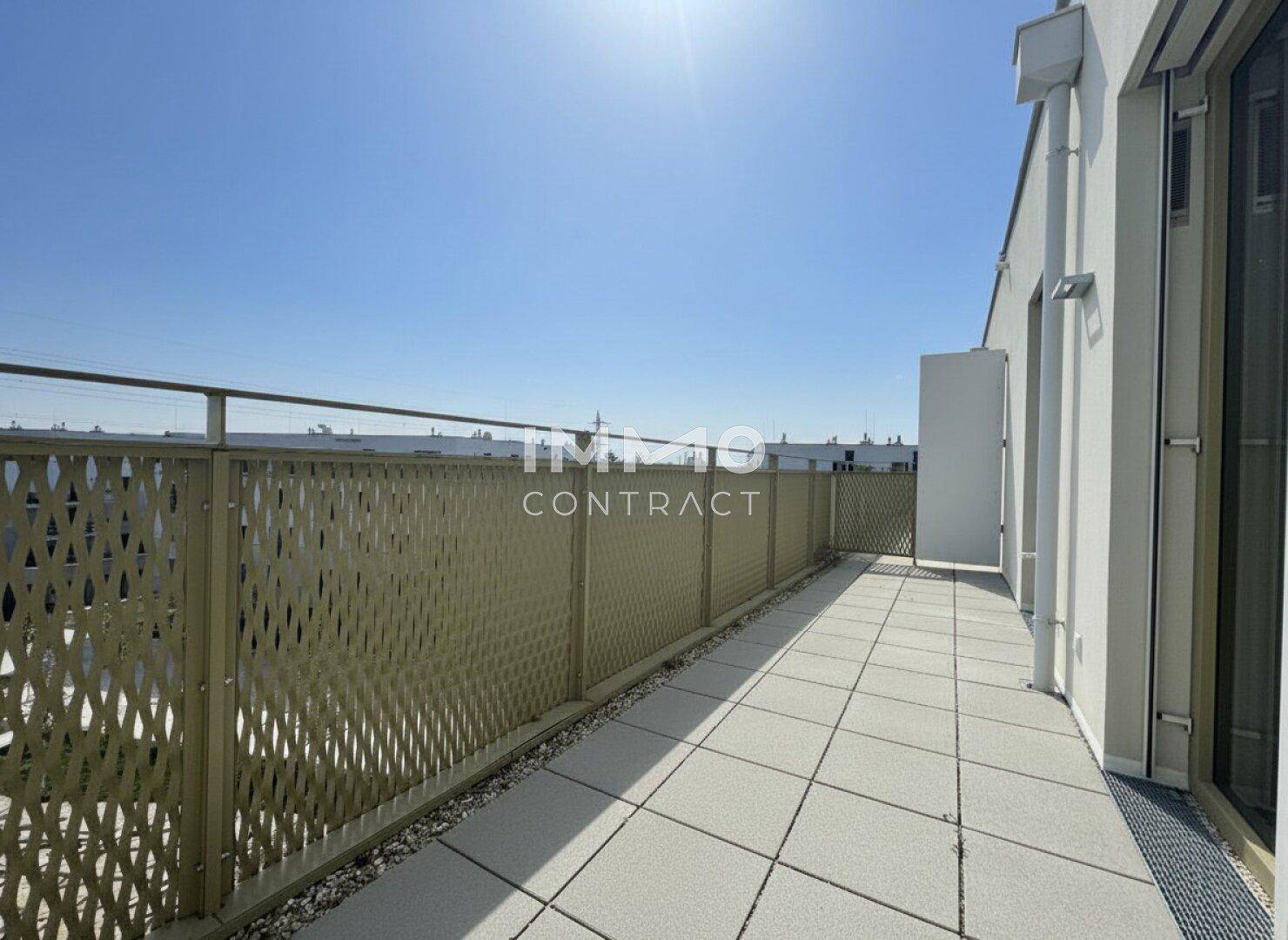 Heller Balkon mit Fliesenboden und weitem Blick über die Nachbarschaft.