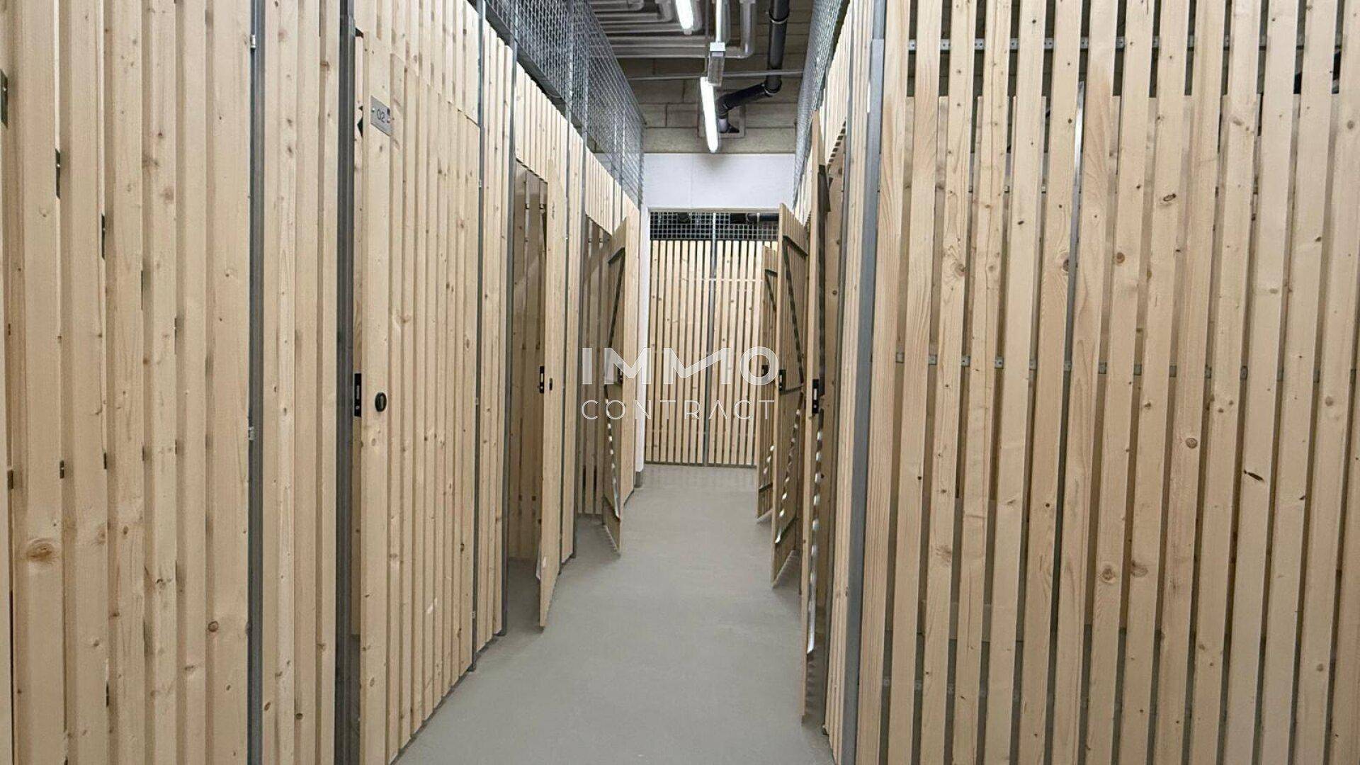 Kellerabteile mit Holzlattenwänden, die individuellen Stauraum für Bewohner bieten.
