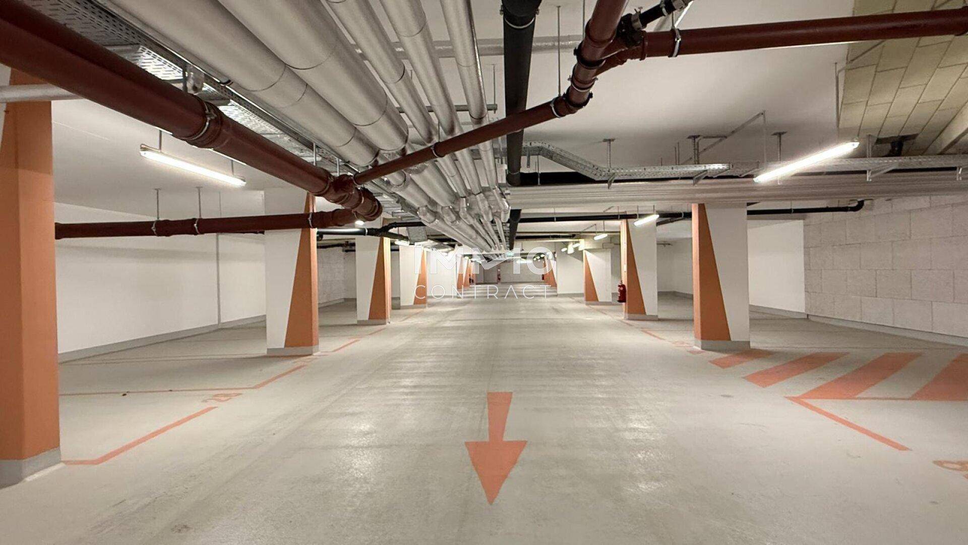 Tiefgarage mit markierten Parkplätzen und guter Beleuchtung, bietet sichere Stellplätze für Fahrzeuge.