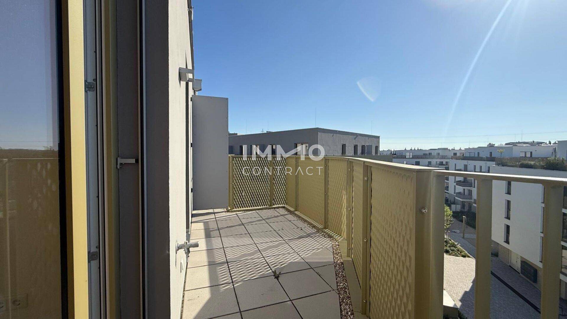 Sonniger Balkon mit Blick auf die Umgebung und moderne Wohngebäude.