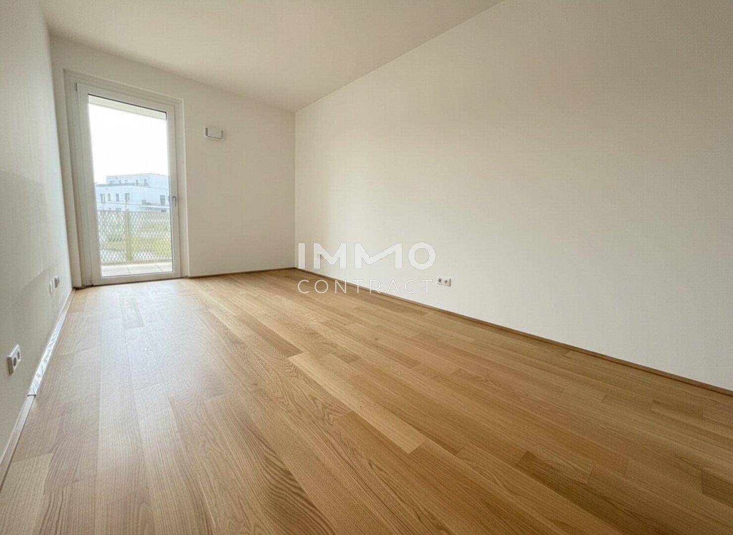 Unmöblierter Raum mit Holzboden und Zugang zu einem kleinen Balkon oder französischen Balkon.