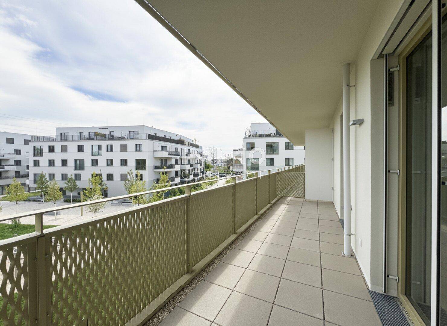 Geräumiger Balkon mit moderner Metallbrüstung und Blick auf die umliegenden Gebäude.