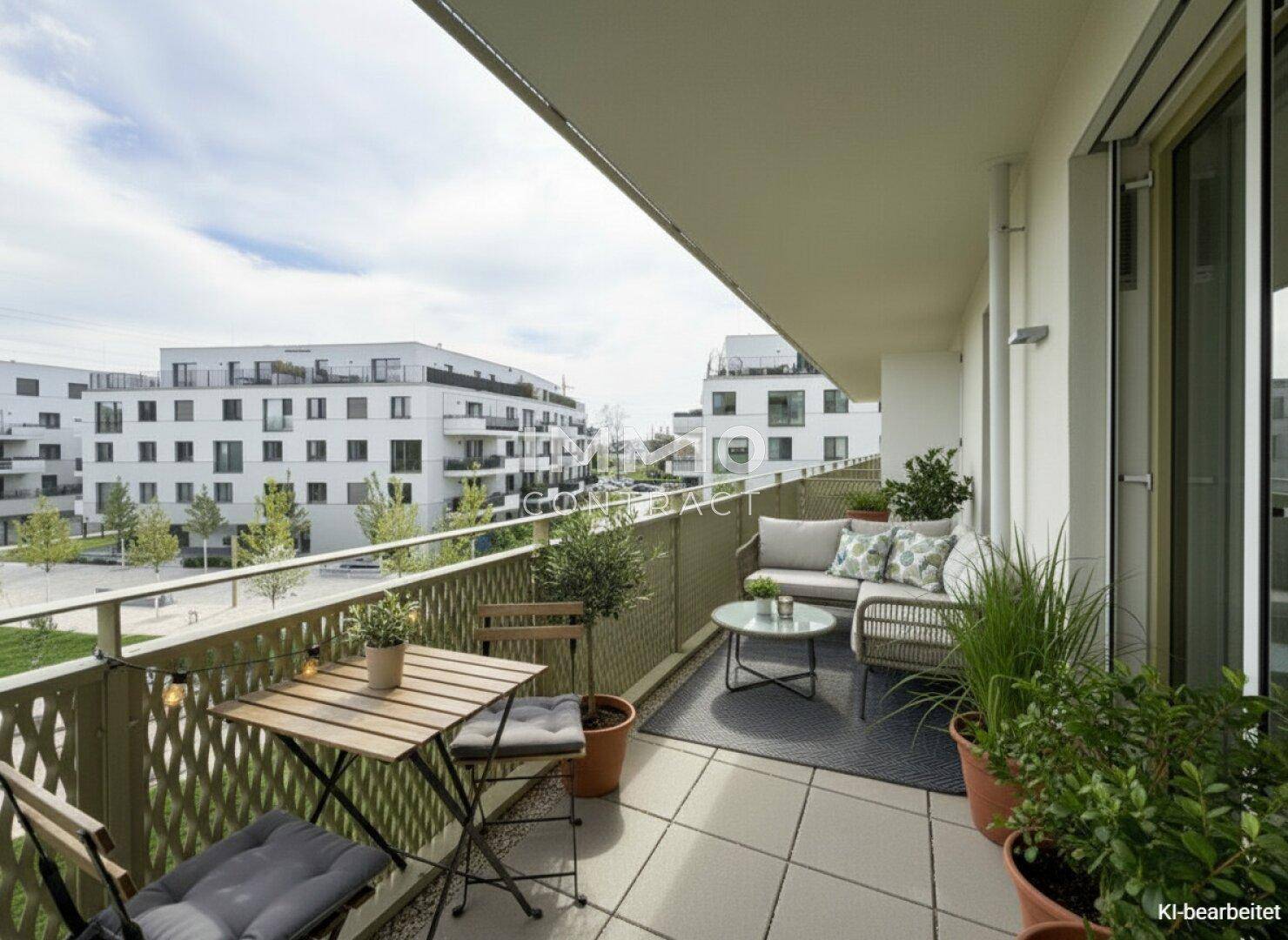 Möblierter Balkon mit Sitzgelegenheiten und Blick auf die moderne Wohnanlage.