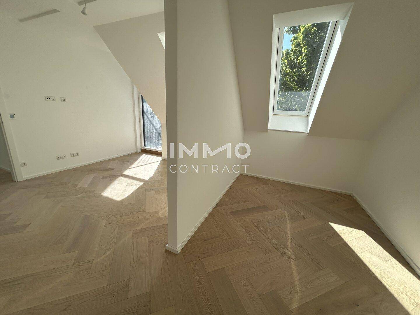 Geräumiger, heller Raum im Dachgeschoss mit schrägen Wänden und einem Dachfenster.
