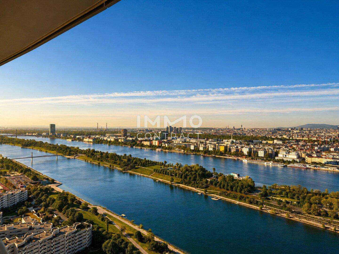 Weitläufiger Blick auf die Stadt, den Fluss und die umliegende Landschaft bei sonnigem Wetter.