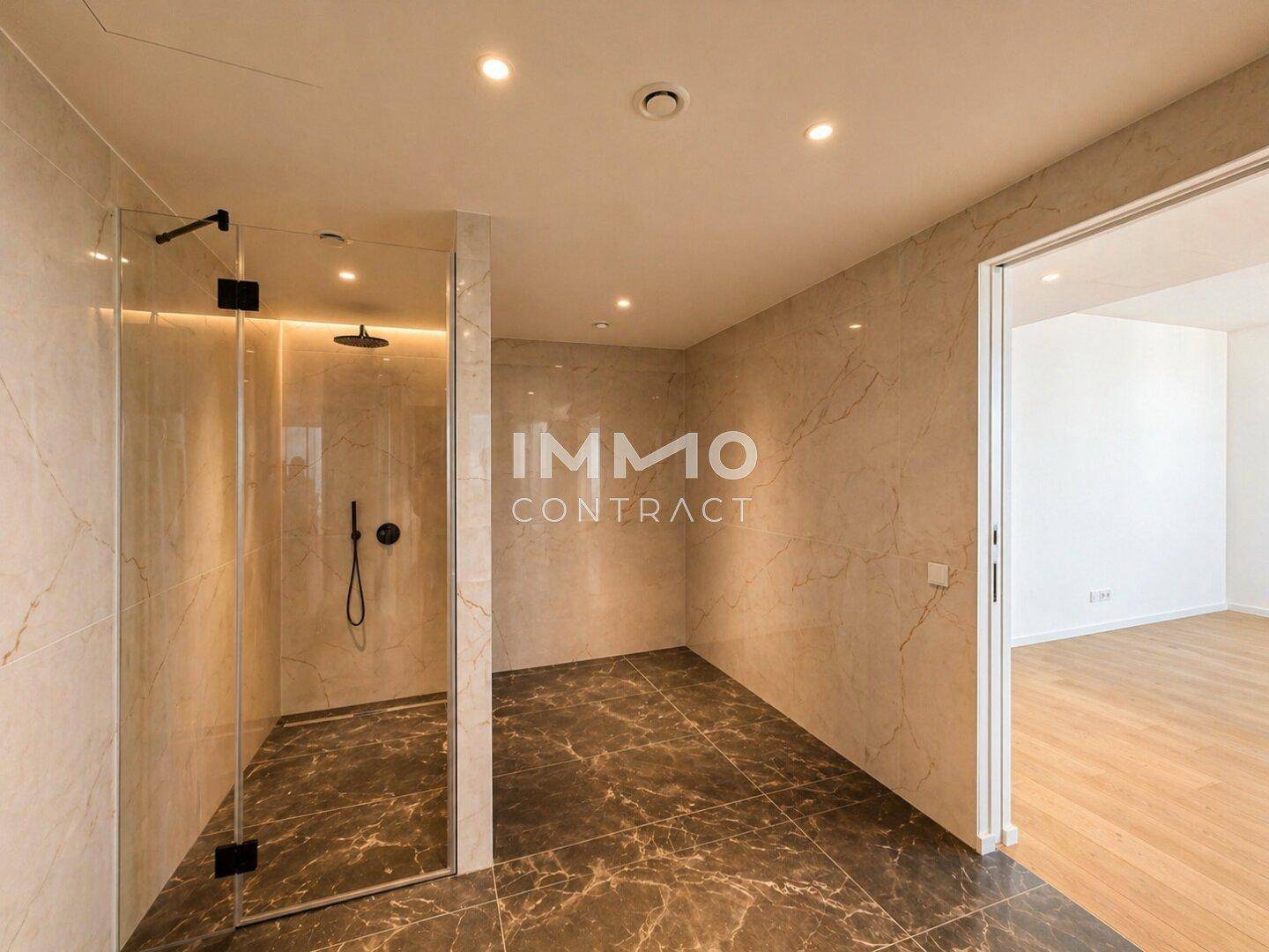Geräumiges Badezimmer mit begehbarer Dusche, Marmorfliesen und Zugang zu einem weiteren Raum.