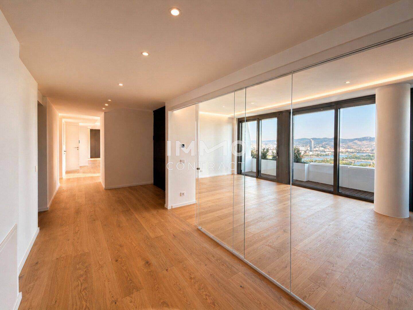 Heller Flur mit Holzboden und verspiegelter Wand, der zu weiteren Räumen und Fenstern führt.