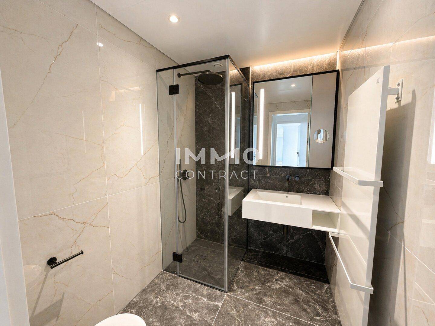 Modernes Badezimmer mit begehbarer Dusche, Marmorfliesen und elegantem Waschbecken.