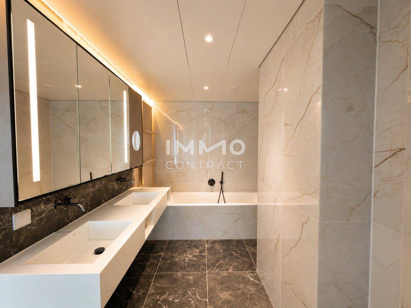 Luxuriöses Badezimmer mit Doppelwaschbecken, Badewanne und Marmorfliesen.