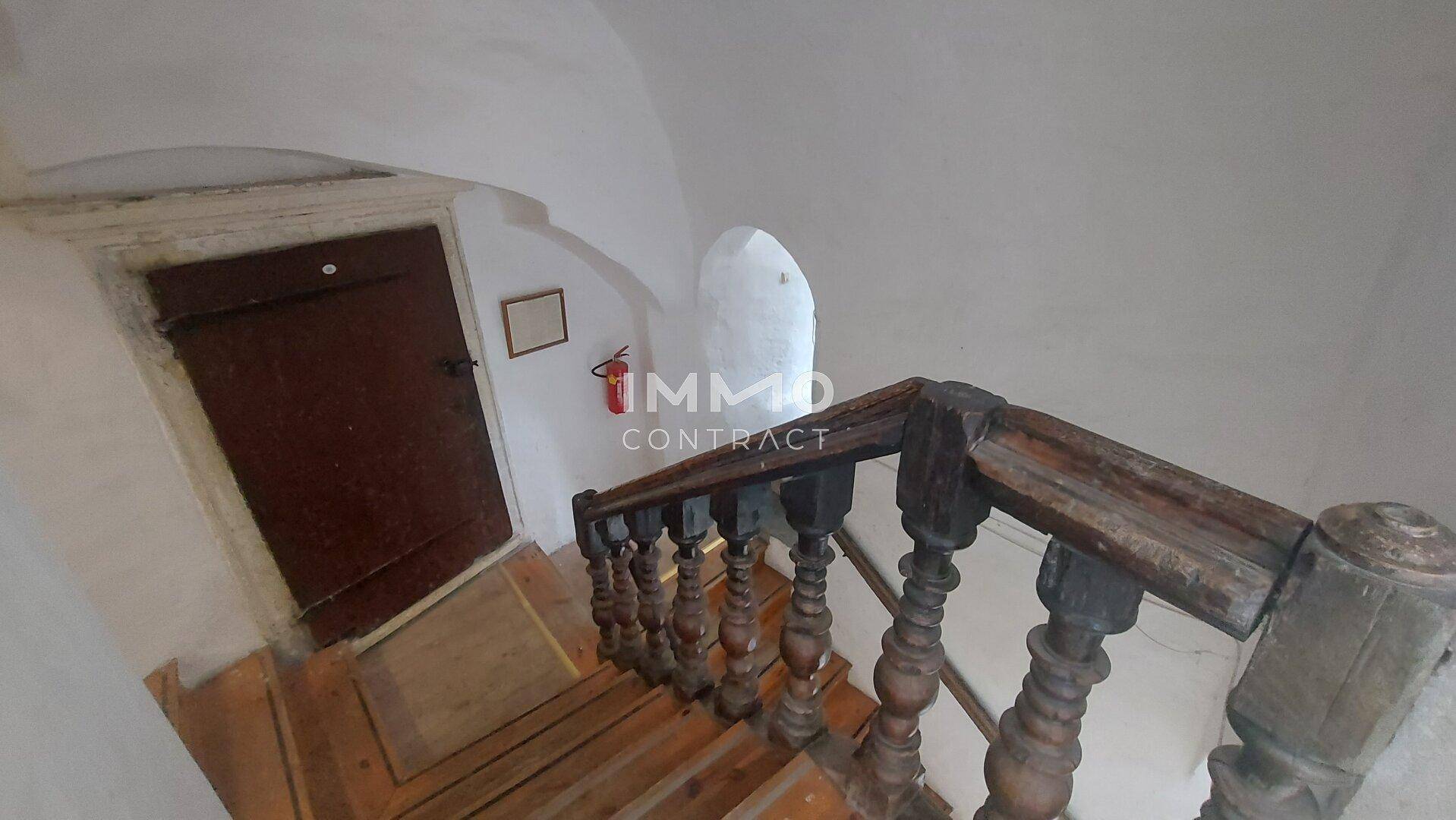 Enges, historisches Treppenhaus mit Holzgeländer und gewölbter Decke.