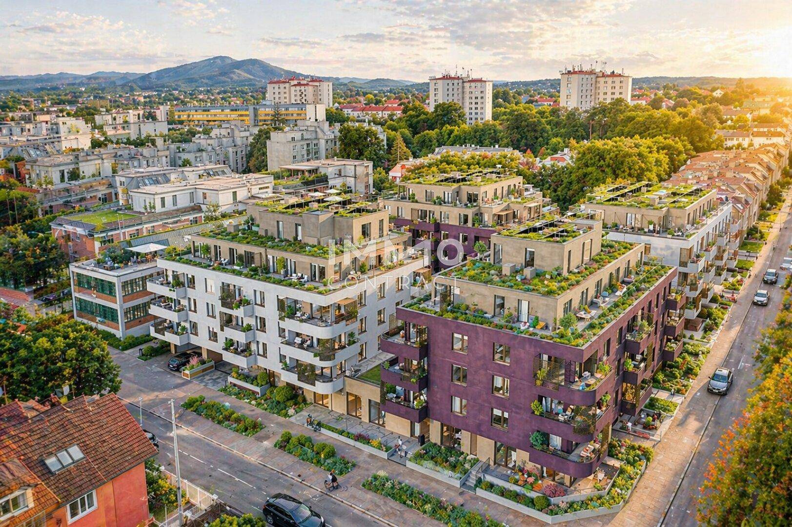 Luftaufnahme eines modernen Wohnkomplexes mit begrünten Dächern und Balkonen in städtischer Umgebung.
