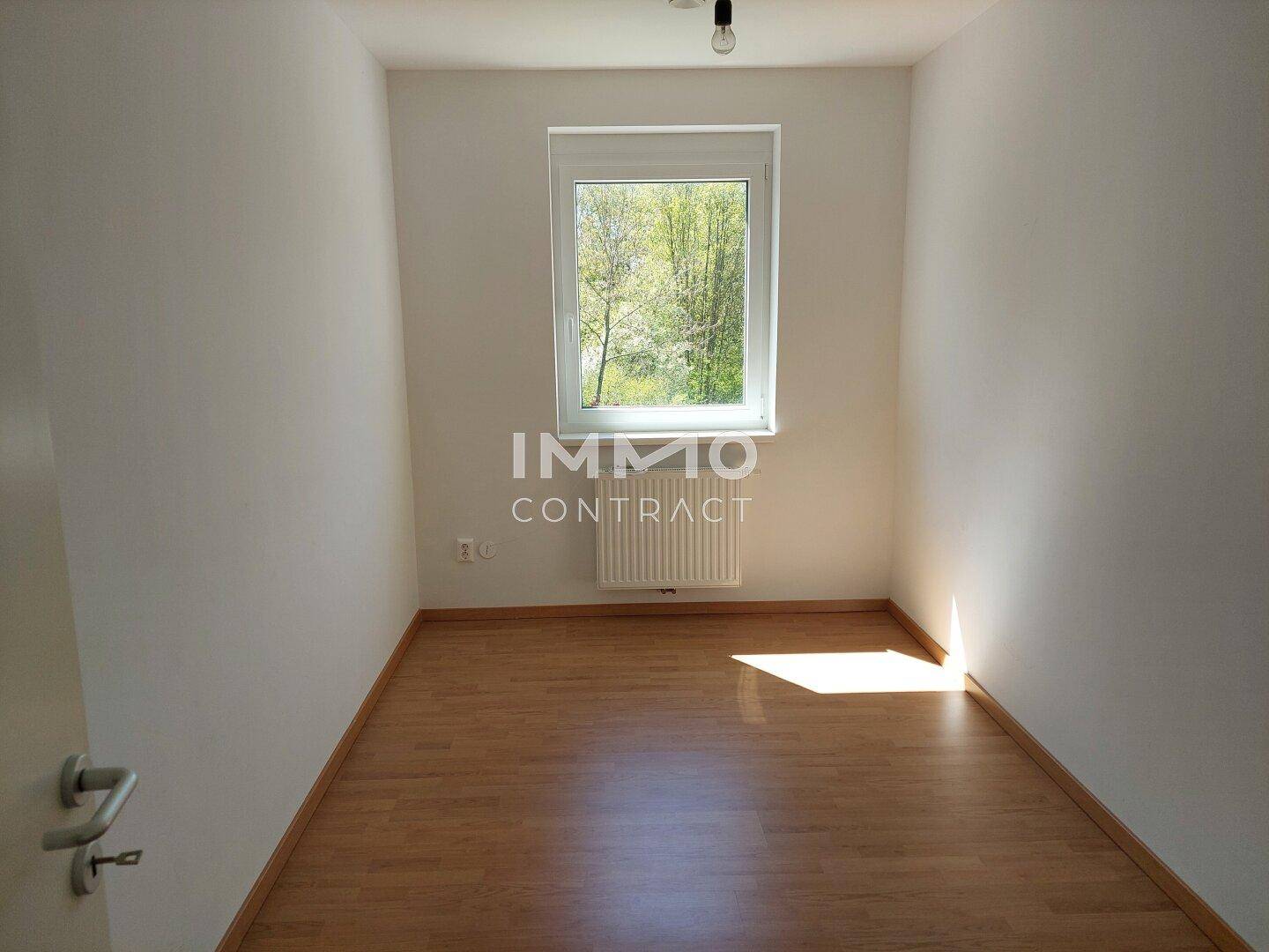 Kleiner, heller Raum mit Holzboden, Fenster und Heizkörper, geeignet als Kinder- oder Arbeitszimmer.