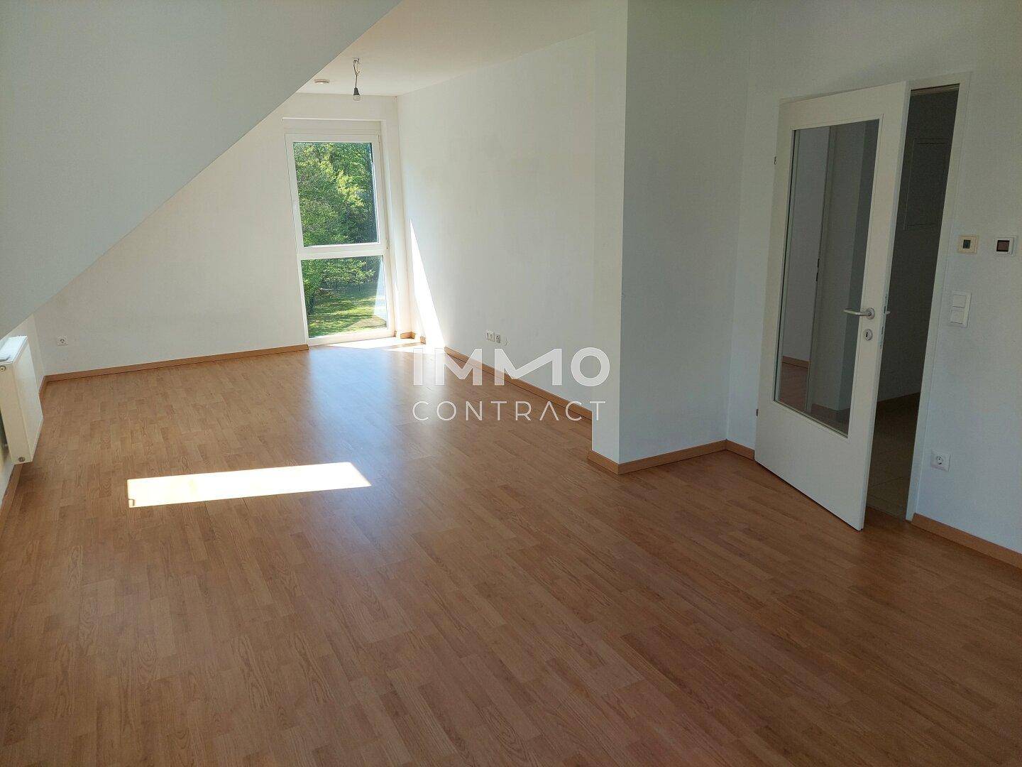 Heller, leerer Raum mit Holzboden, großen Fenstern und viel Tageslicht, ideal für individuelle Gestaltung.