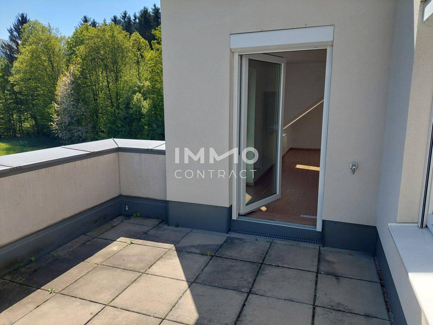 Sonniger Terrassenbereich mit Fliesenboden und direktem Zugang zum Innenraum der Wohnung.