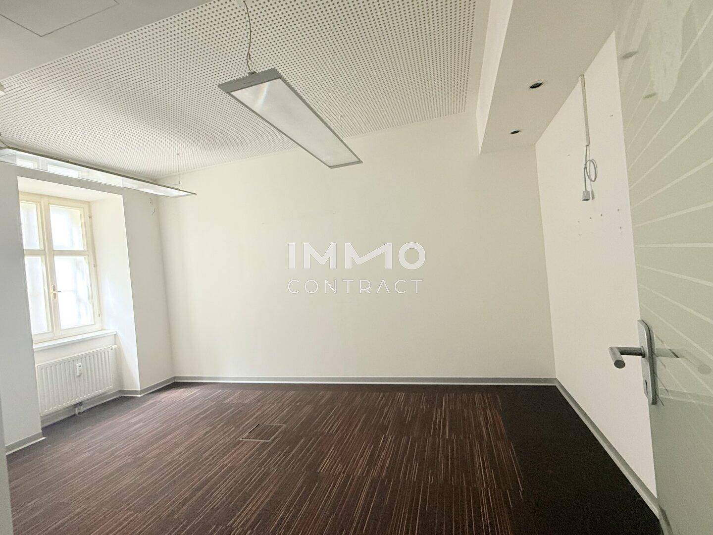 Einzelbüro mit Teppichboden, Fenster und moderner Deckenbeleuchtung, bereit zur Nutzung.
