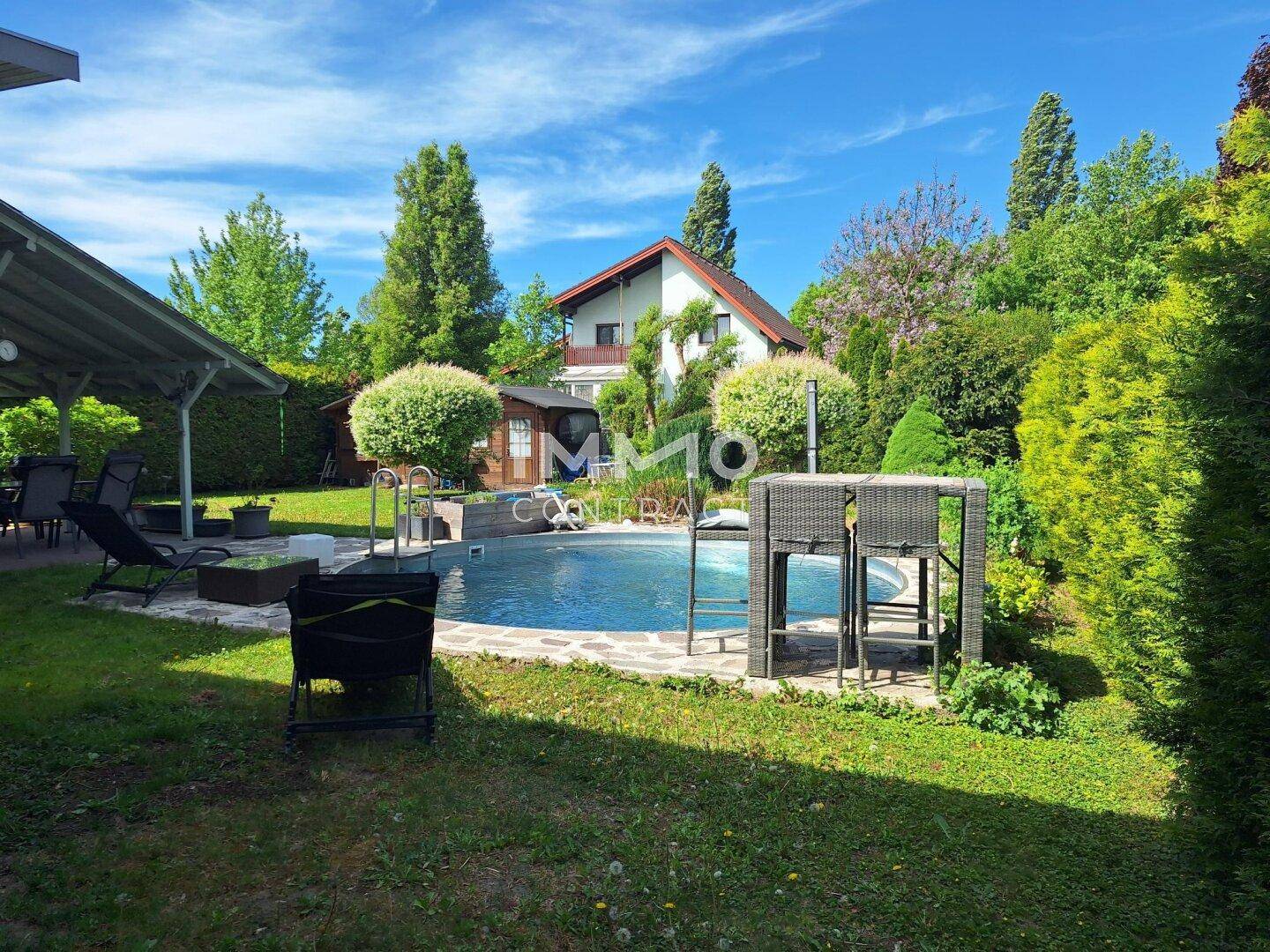 Großzügiger Gartenbereich mit Pool, überdachter Terrasse und viel Grün.