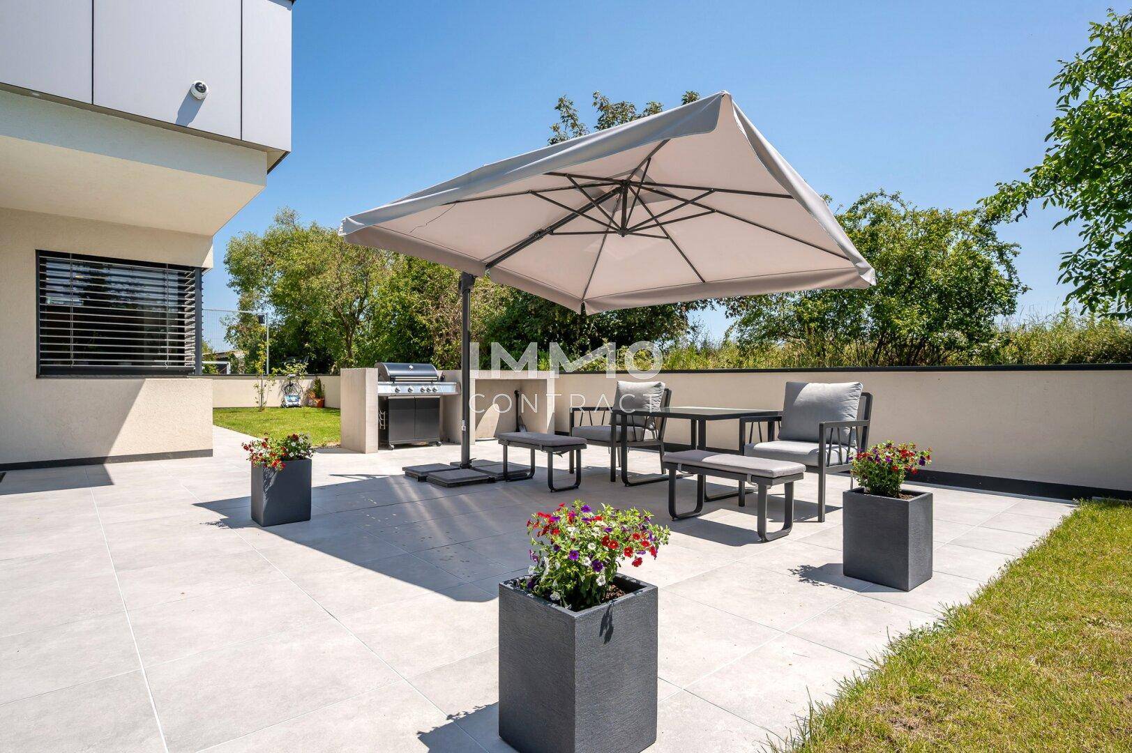 Gemütliche Terrasse mit modernen Gartenmöbeln und Grillbereich, ideal für sommerliche Abende.