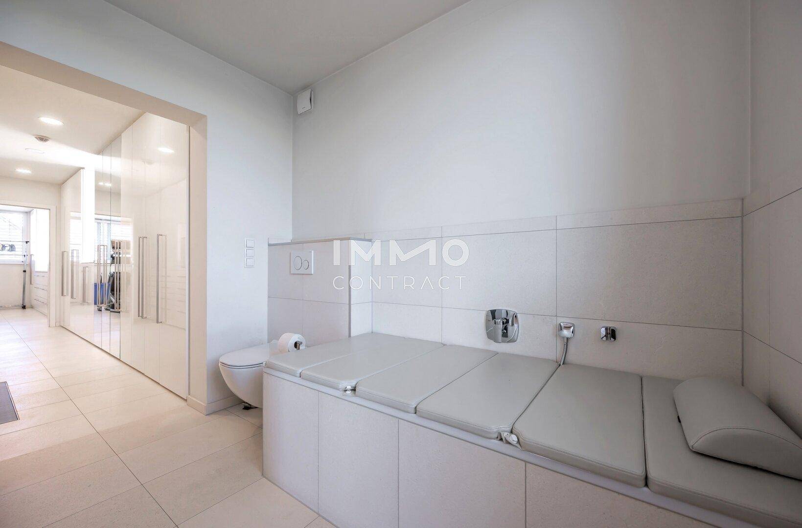 Modernes Badezimmer mit Toilette und einer gepolsterten Liegefläche, möglicherweise für Wellness.