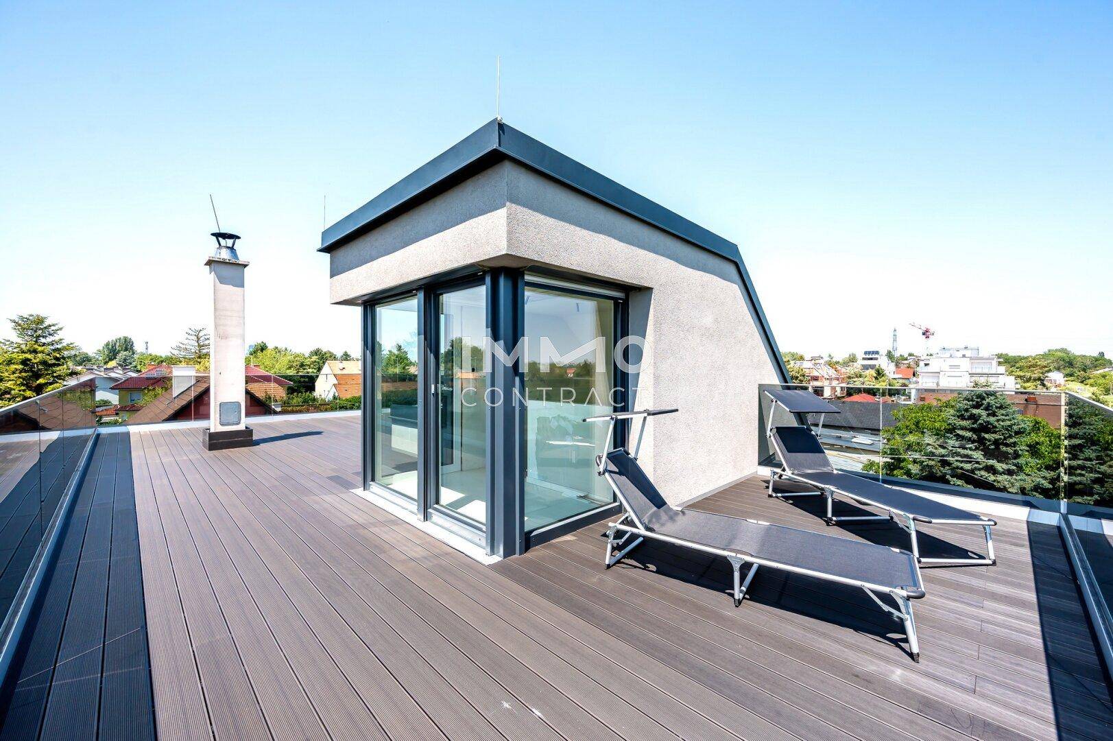 Geräumige Dachterrasse mit Liegestühlen und einem modernen Aufbau, ideal zum Entspannen.