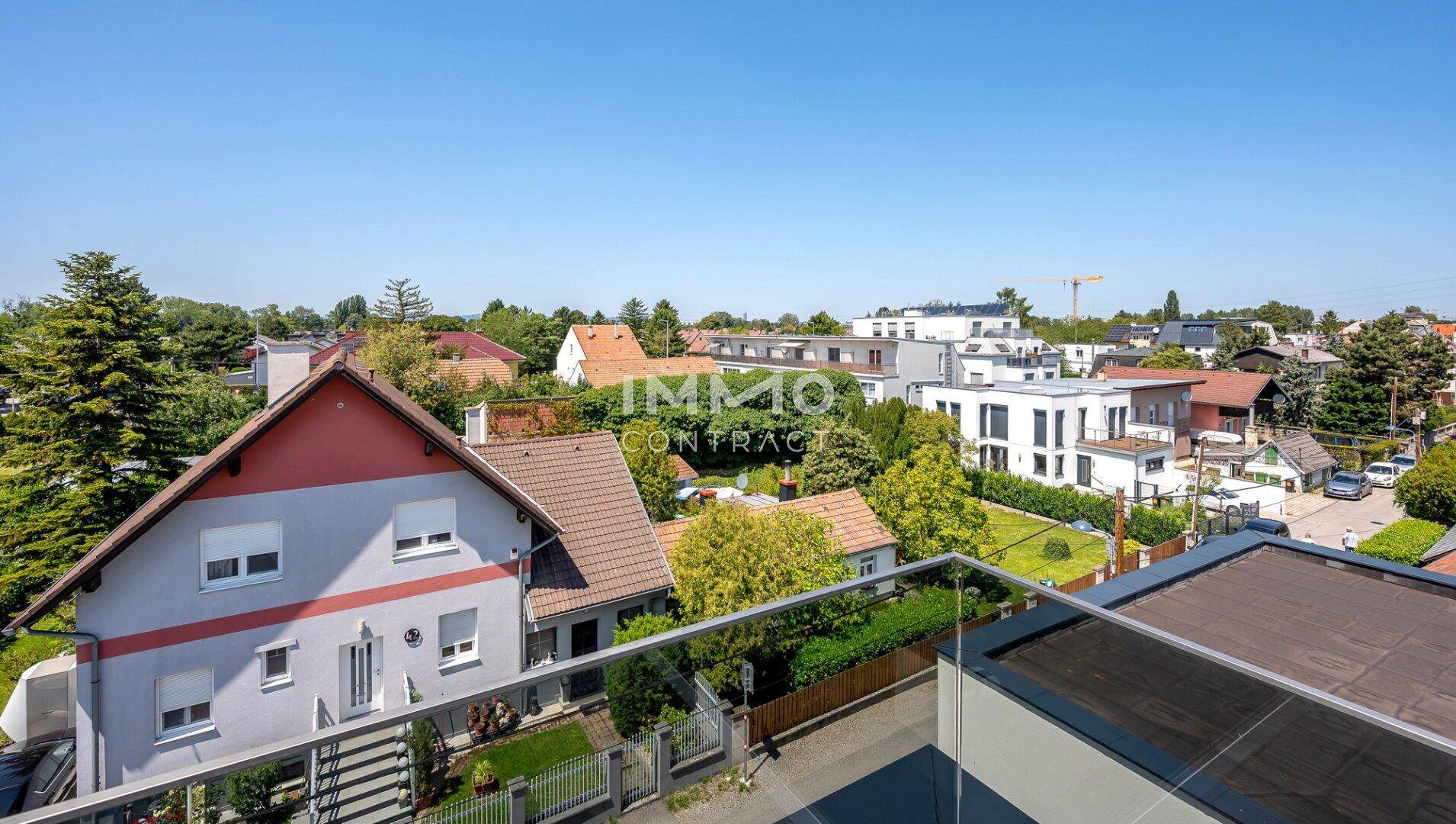 Panoramablick über eine Wohnsiedlung mit unterschiedlichen Häusern und viel Grün.