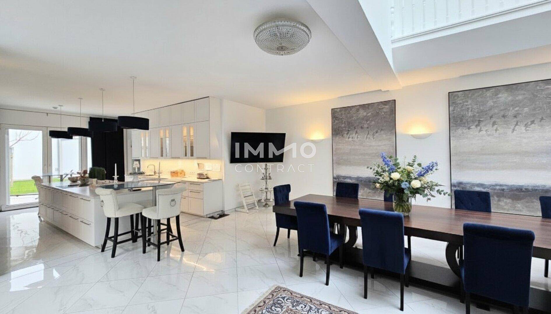 Moderne offene Küche mit weißer Insel und Essbereich, ideal für geselliges Beisammensein.