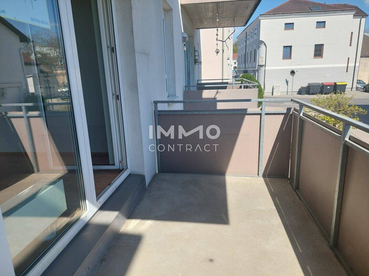 Heller Balkon mit Metallgeländer und Blick auf die umliegende Straße.