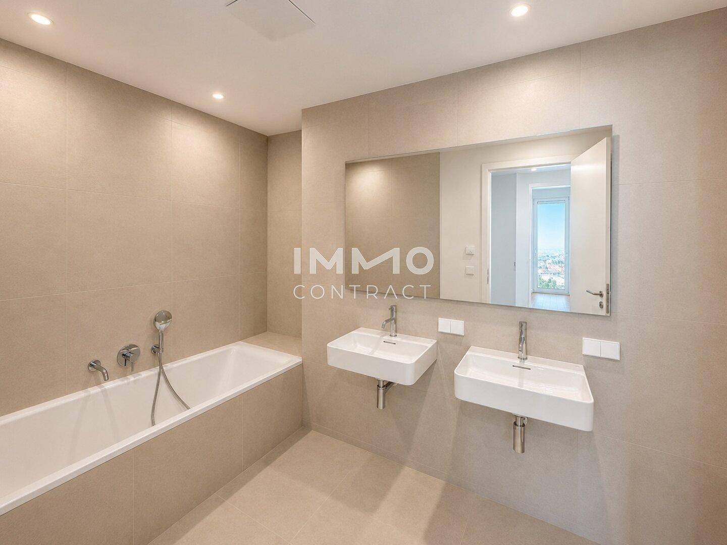 Modernes Badezimmer mit Doppelwaschbecken, Badewanne und großen beigefarbenen Fliesen.