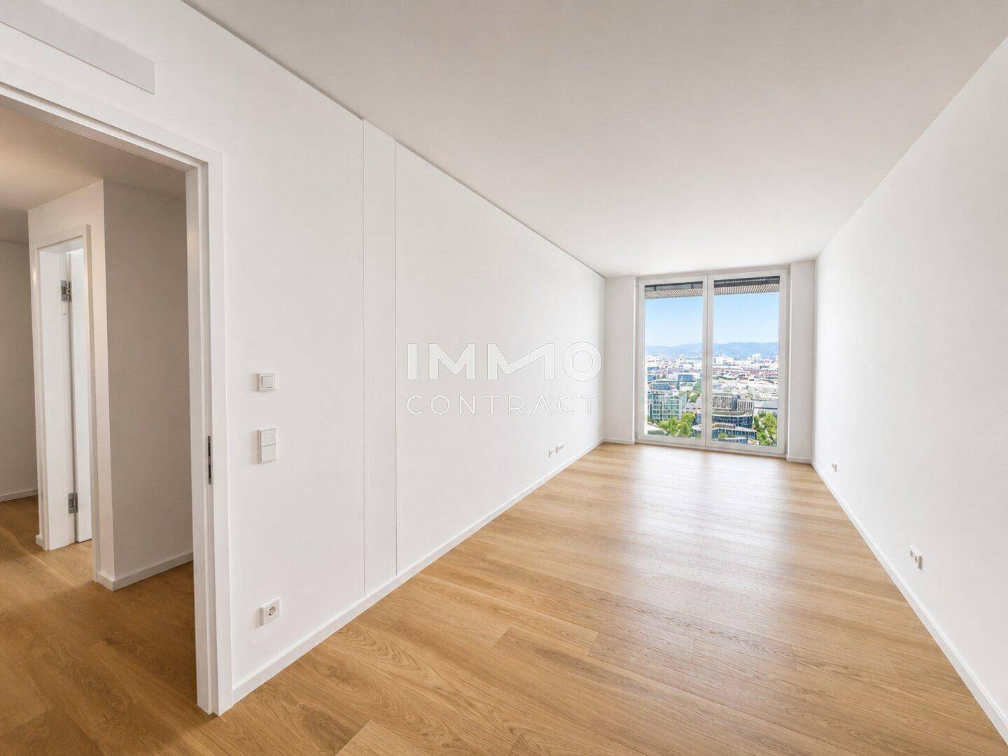 Helles Schlafzimmer mit Eichenparkettboden und großen Fenstern, die einen weiten Stadtblick bieten.