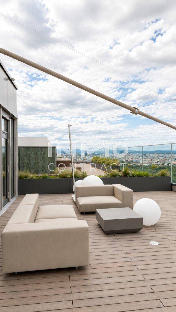 Dachterrasse mit modernen Lounge-Möbeln und Panoramablick über die Stadt.