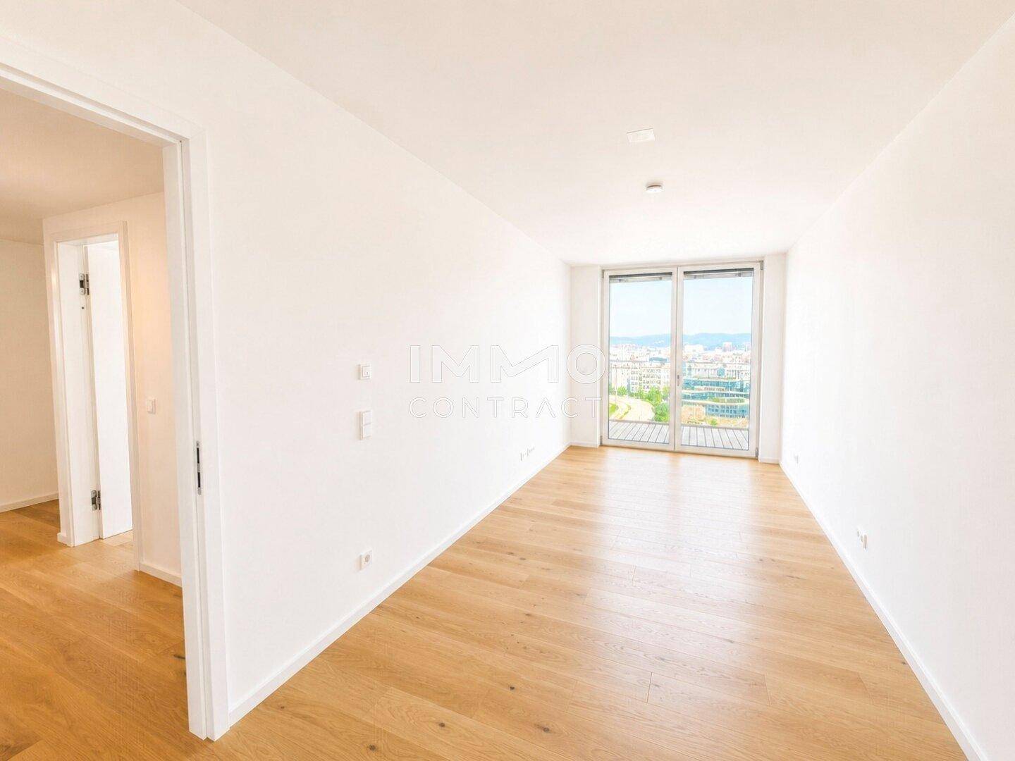 Helles Schlafzimmer mit Holzboden und großen Fenstern, die einen weiten Blick bieten.