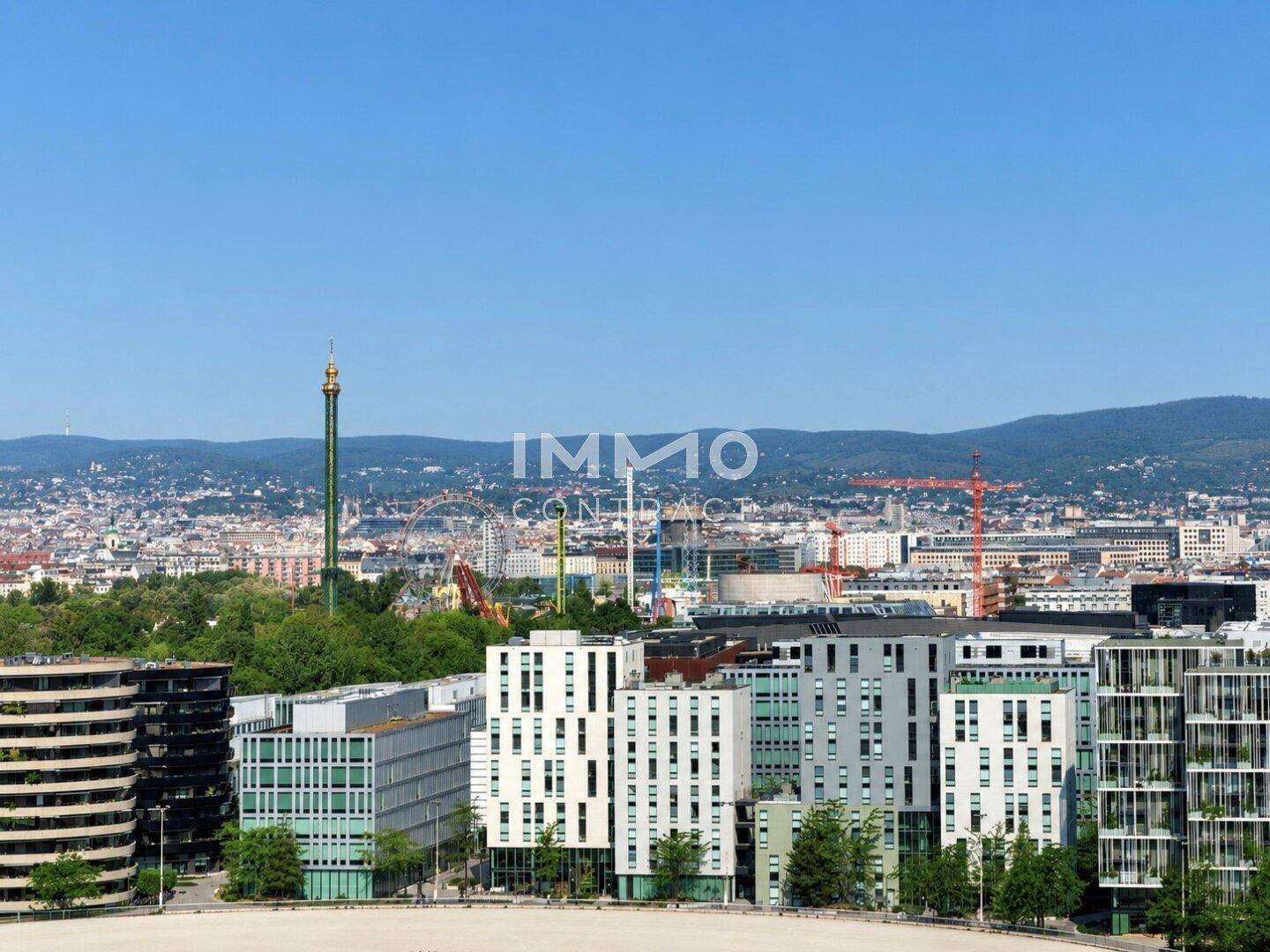 Panoramablick über die Stadt Wien mit modernen Gebäuden und dem Prater im Hintergrund.