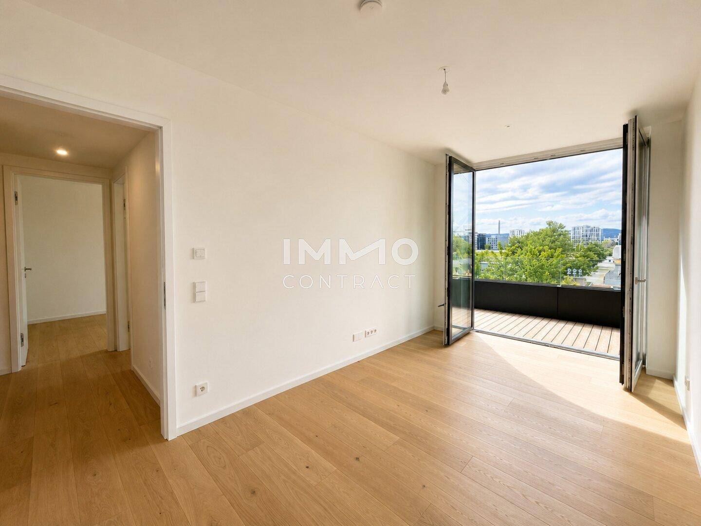 Helles Schlafzimmer mit Parkettboden und Zugang zu einem privaten Balkon.