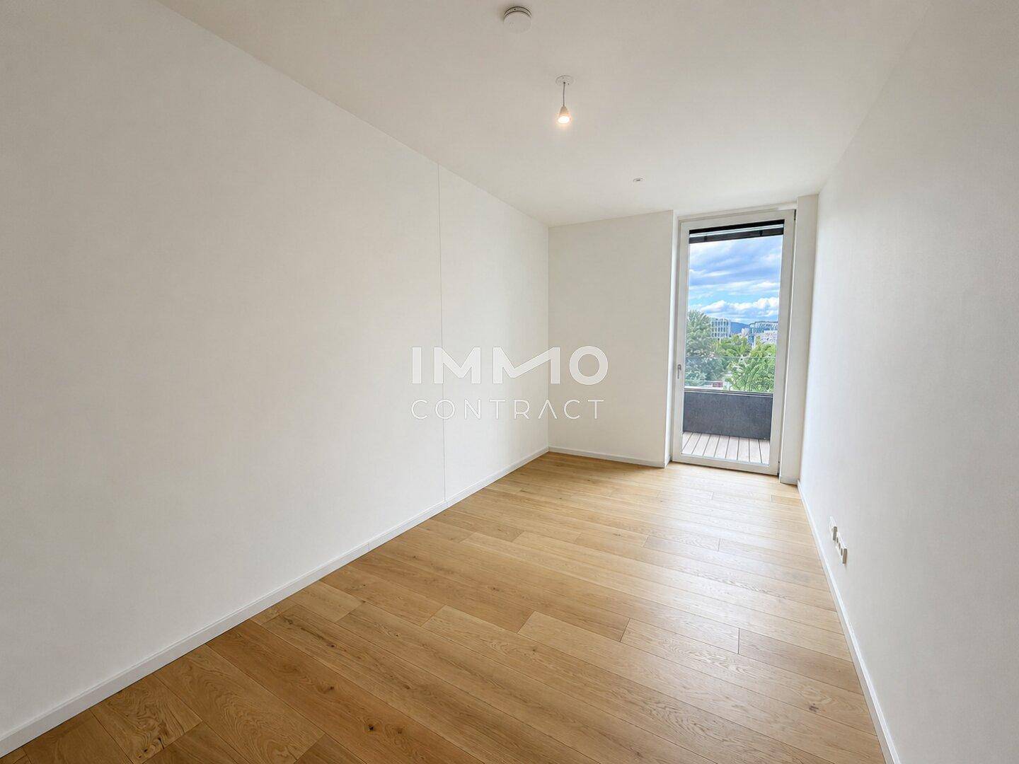 Geräumiges Schlafzimmer mit Holzboden und Zugang zu einem Außenbereich.