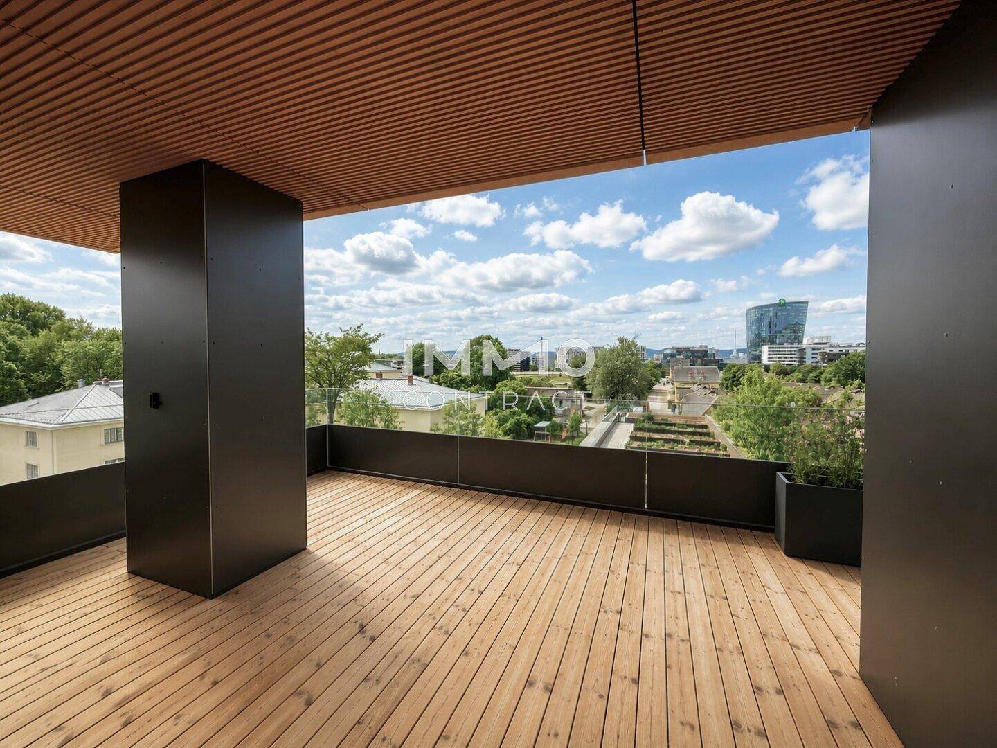 Geräumige Terrasse mit Holzbelag und weitem Blick auf die Stadt und die Umgebung.