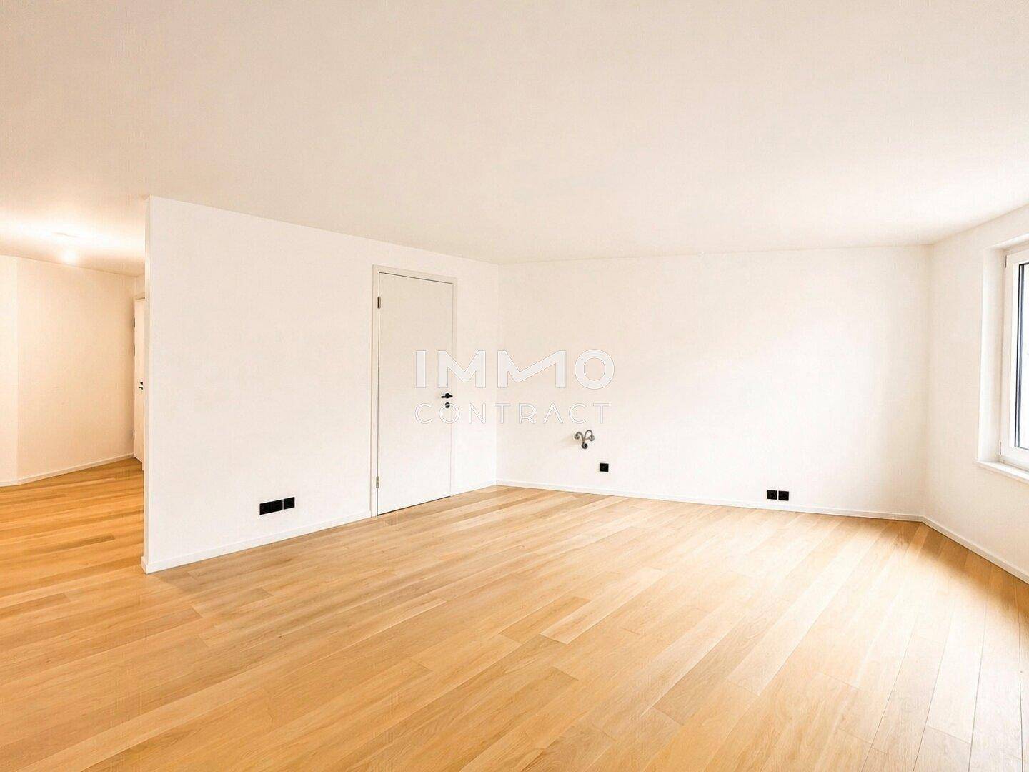 Geräumiges, unmöbliertes Zimmer mit hellem Holzparkett und weißen Wänden, ideal für flexible Nutzung.