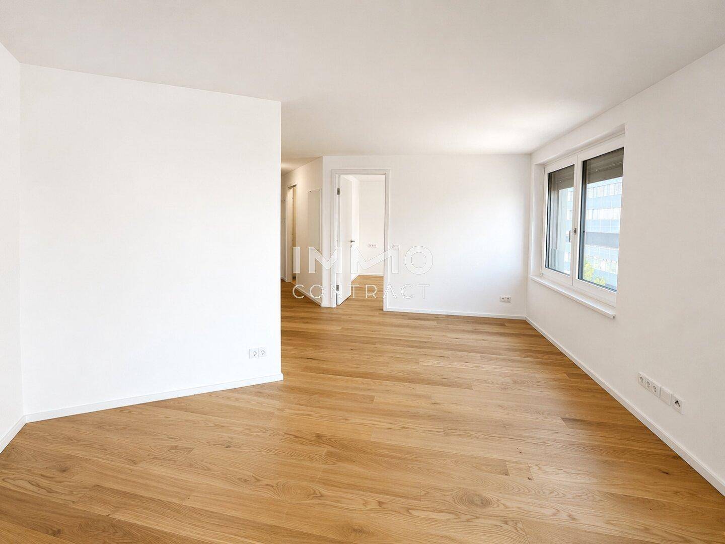 Heller Raum mit Holzboden und großen Fenstern, vielseitig nutzbar als Wohn- oder Schlafzimmer.