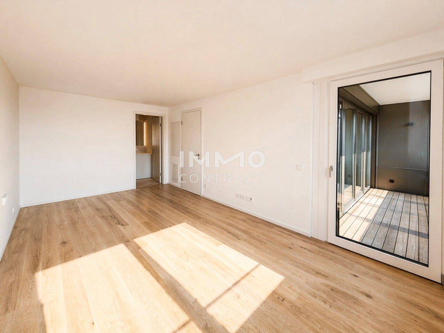 Lichtdurchfluteter Raum mit Holzboden und Zugang zu einem Balkon, ideal für flexible Nutzung.