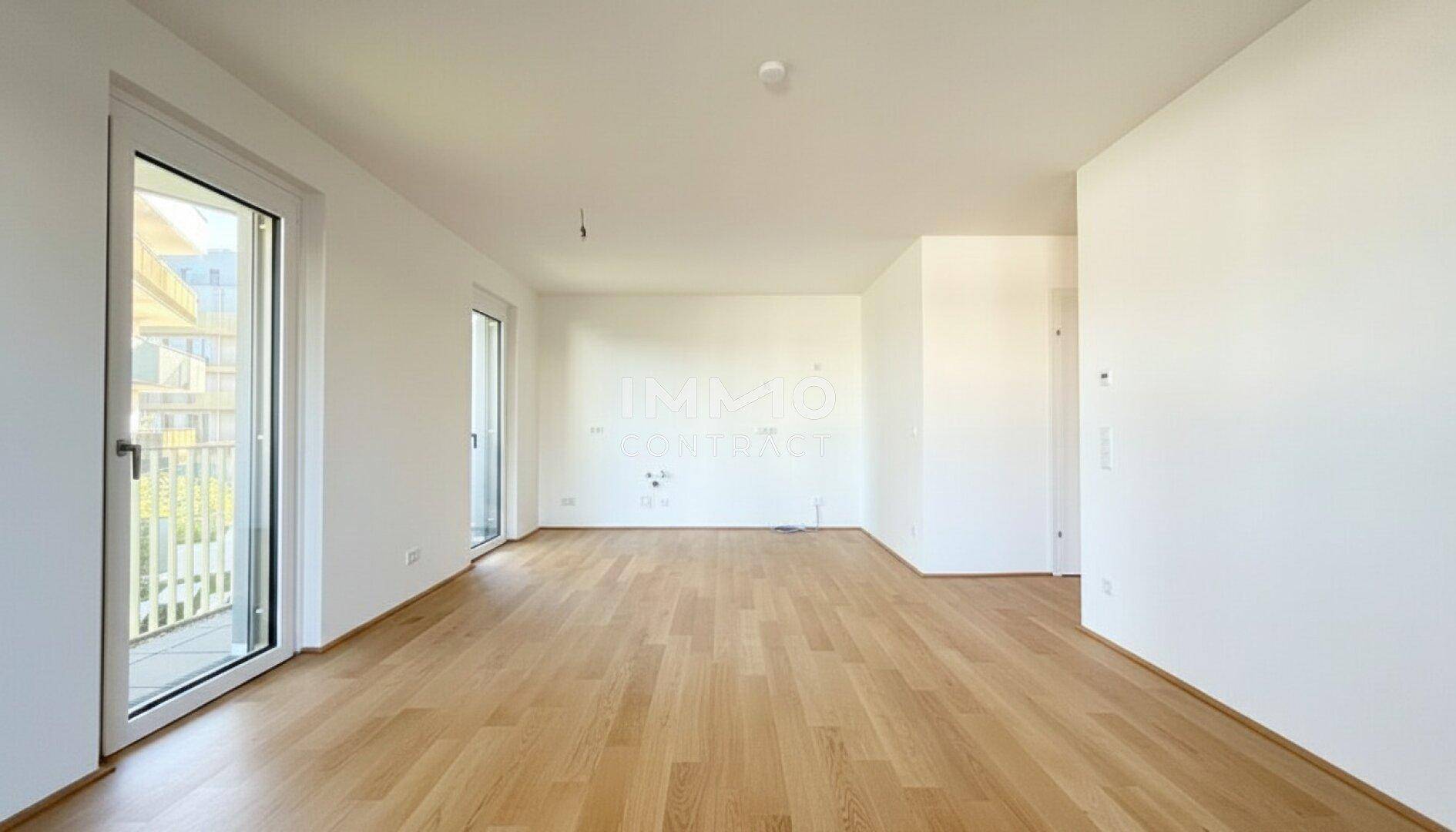 Geräumiger, heller Raum mit Holzboden und großen Fenstern, bereit zur individuellen Gestaltung.