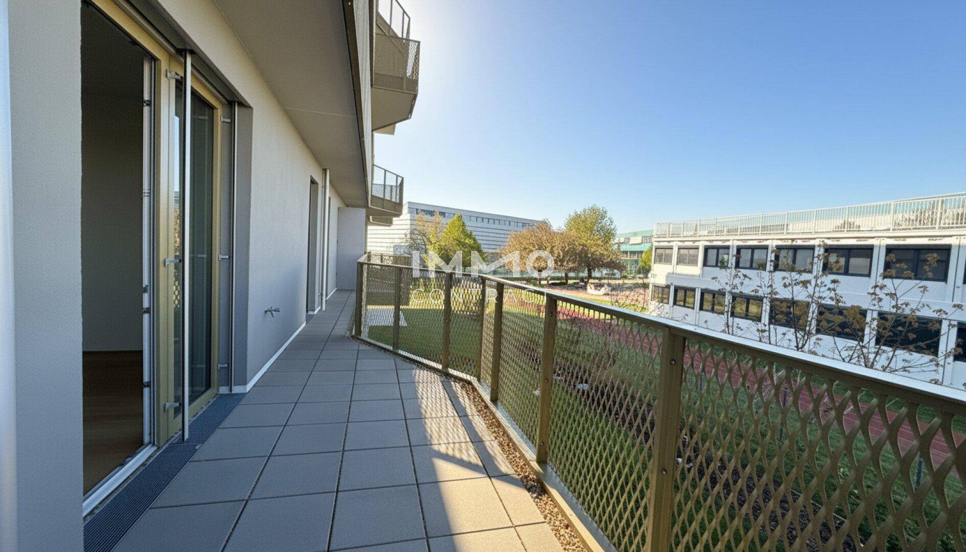 Langer Balkon mit Fliesenboden und Metallgeländer, bietet Blick auf die Umgebung.