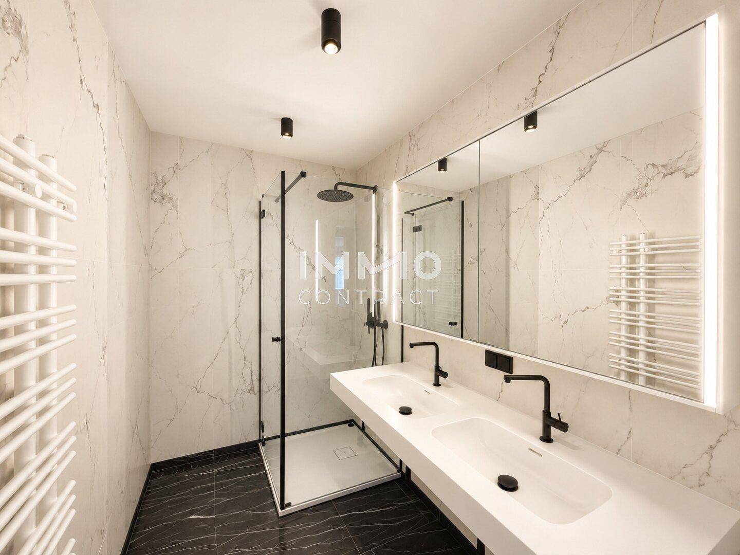 Luxuriöses Badezimmer mit Marmorfliesen, Doppelwaschbecken und großer begehbarer Dusche.